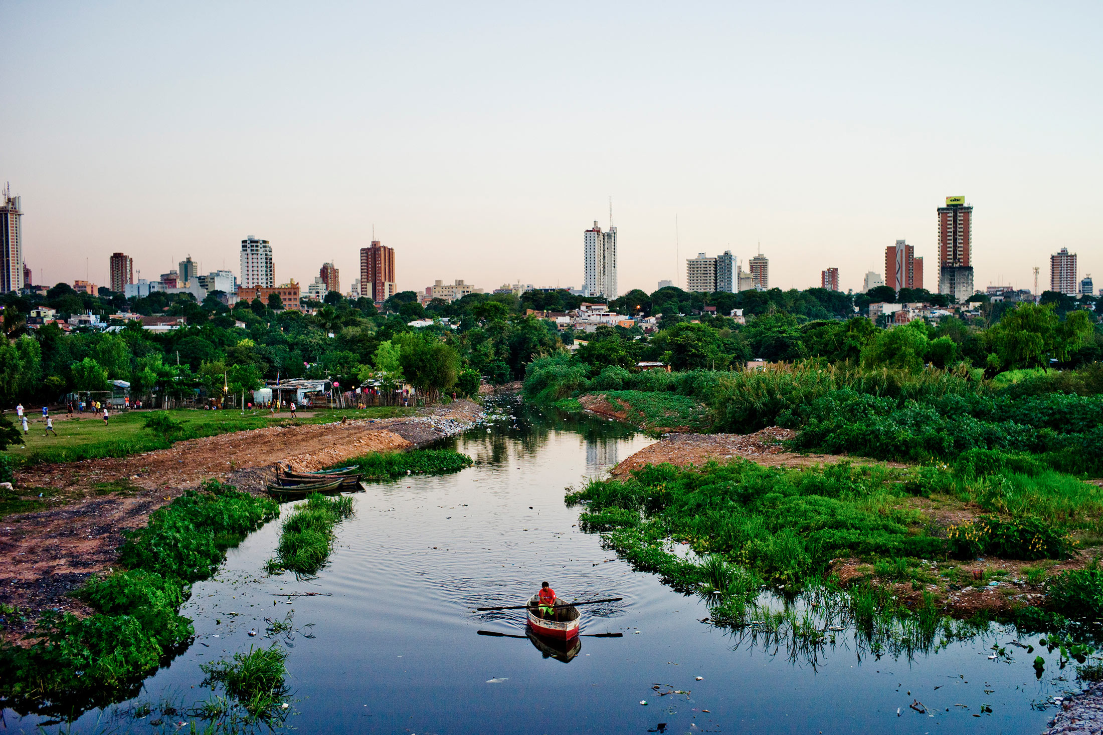 A fisherman rows his boat along polluted waters of La Chacarita in Asunción, Paraguay, Apr. 19, 2013.