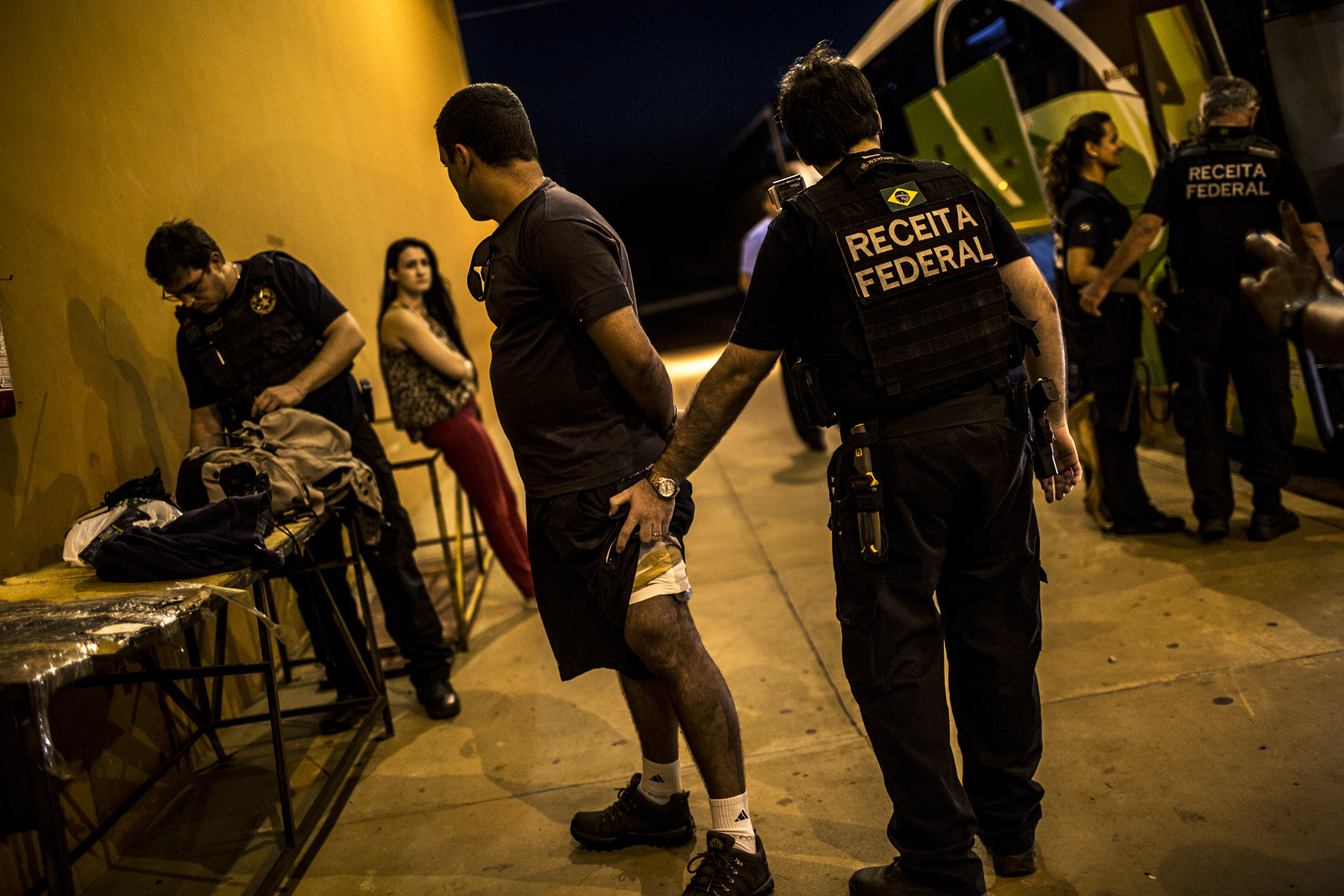 A suspected smuggler is questioned by Brazilian Tax Authority agents near the border with Paraguay in Foz do Iguacu, Brazil on Oct. 7, 2015.