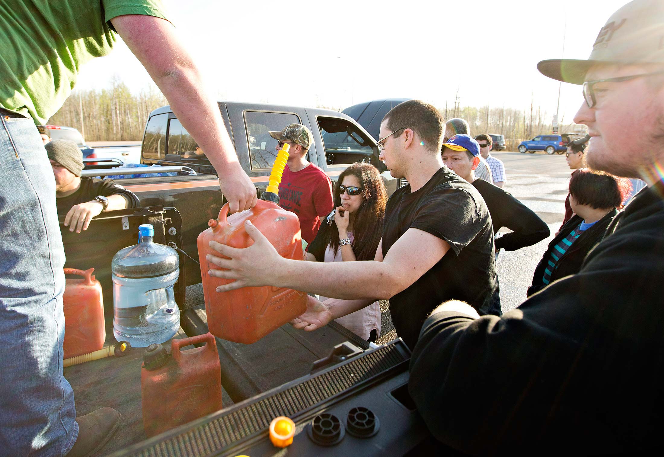People gather for gas handed out at a rest stop near Fort McMurray on May 4