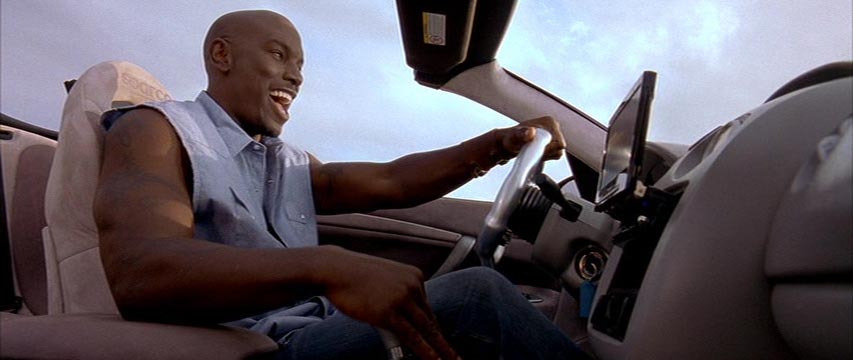 Man in sleeveless shirt, shifting gears in a convertible