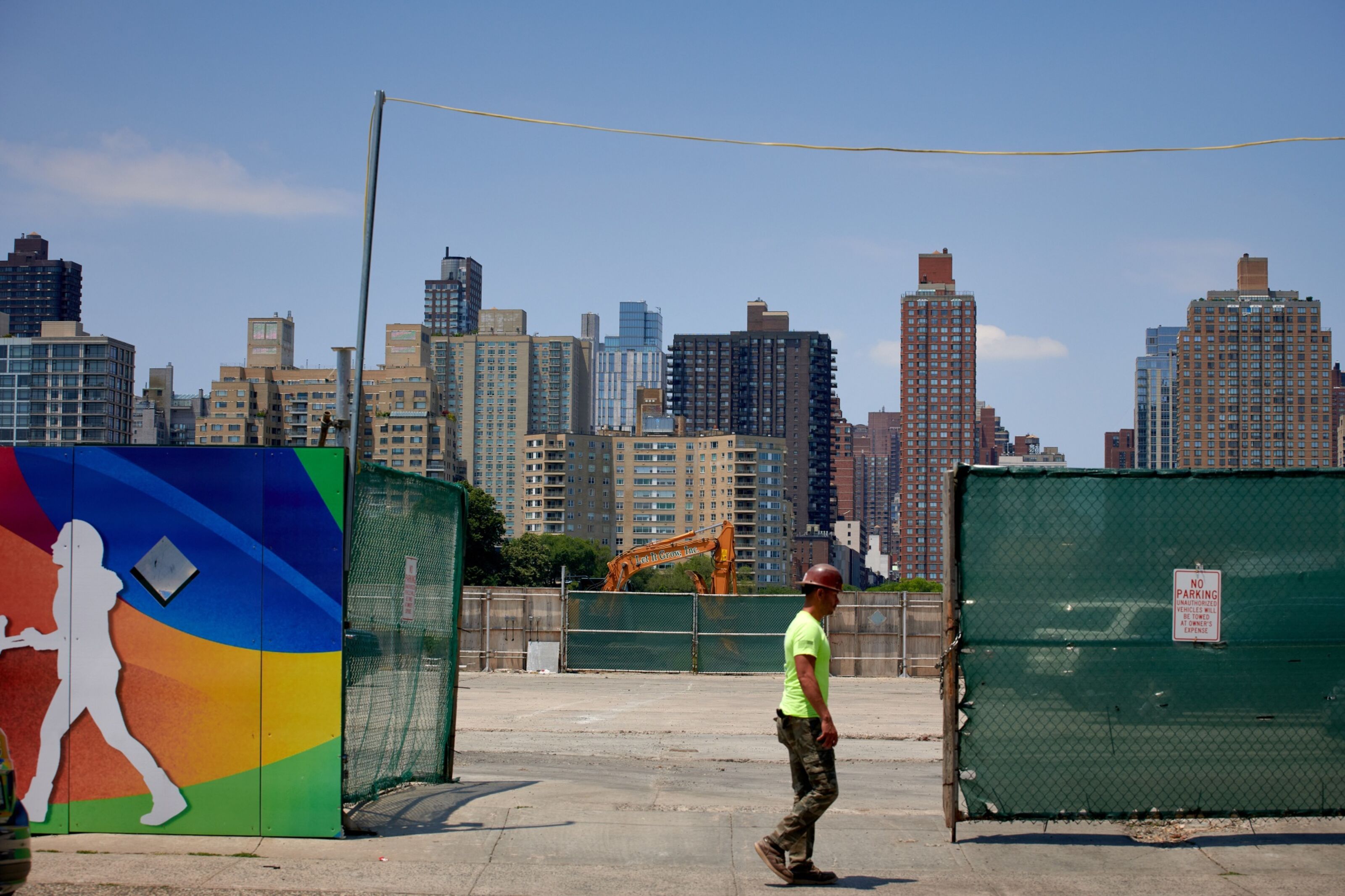 A construction worker walks by a a parking lot
