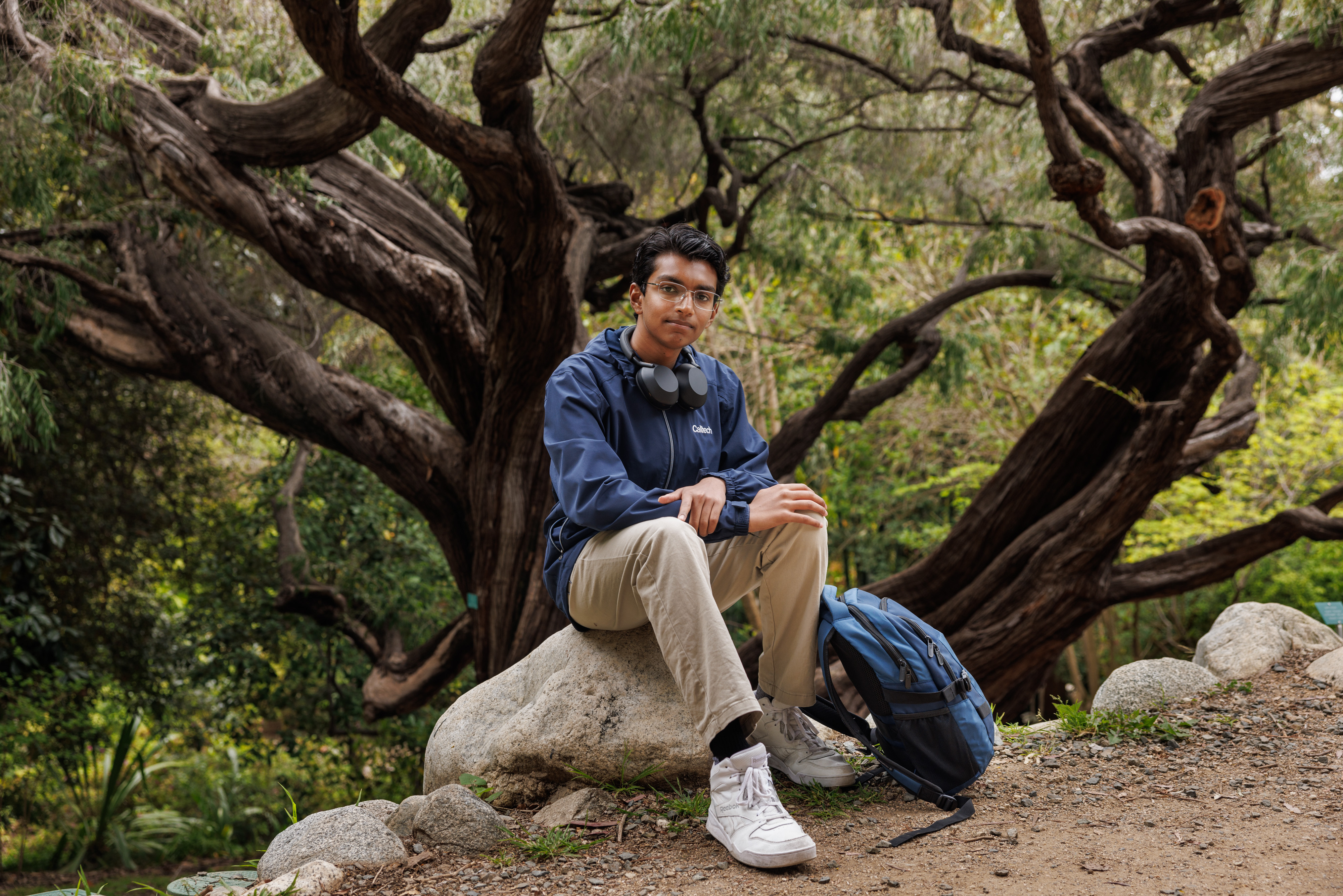Ayush Natarajan sitting on a rock outdoors.